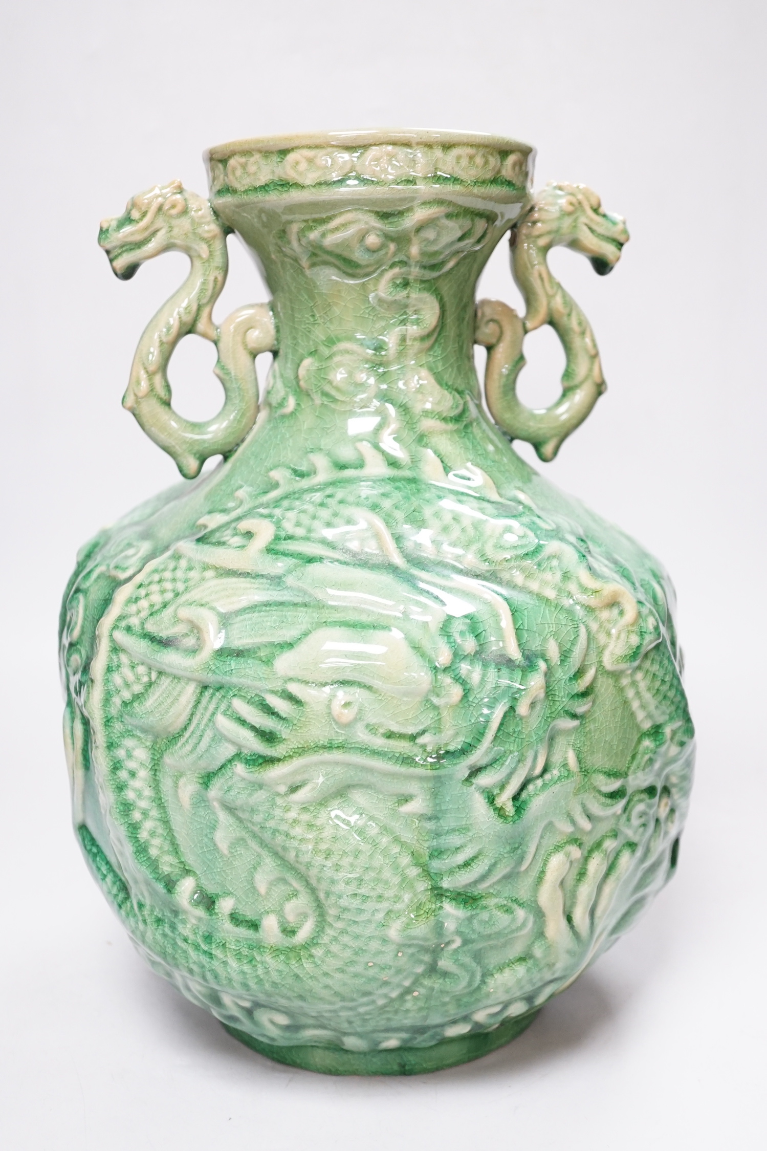 A Chinese green glazed vase with twin zoomorphic handles, decorated in relief with dragons, 35cm high